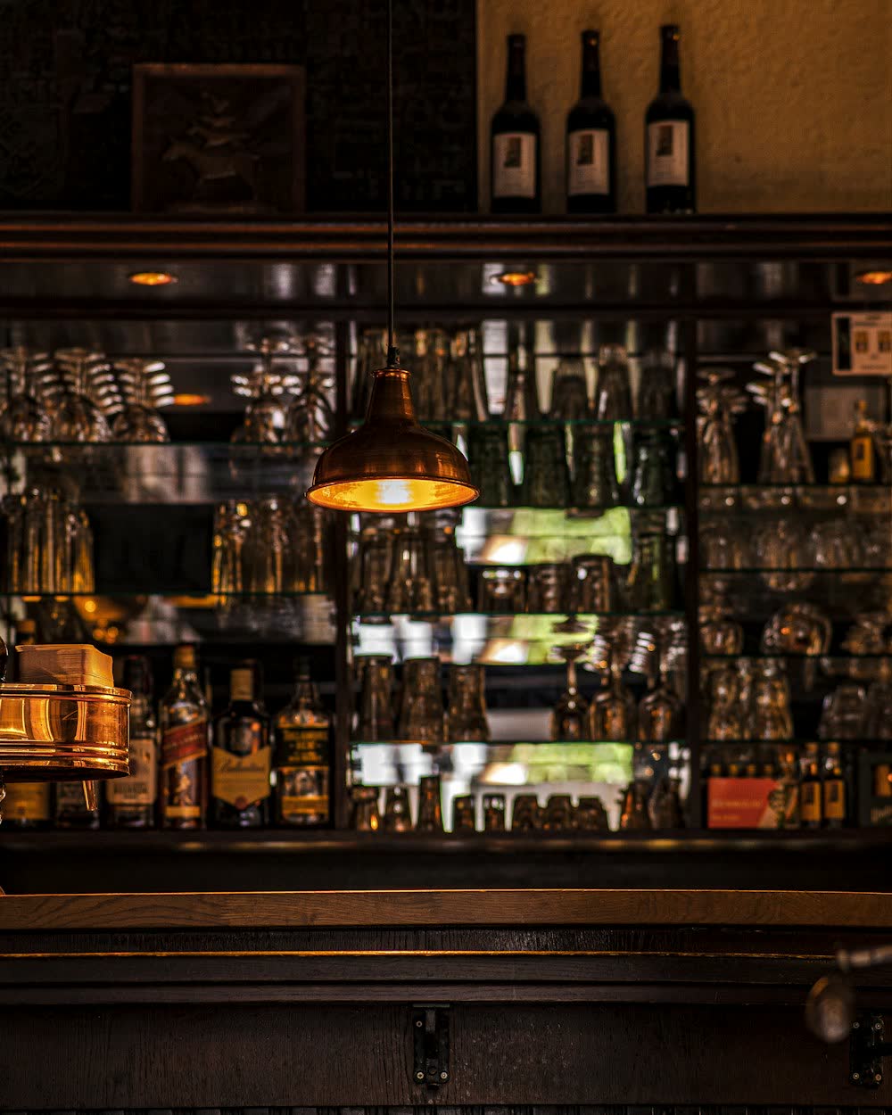 A dimly lit bar with bottles on the back shelves